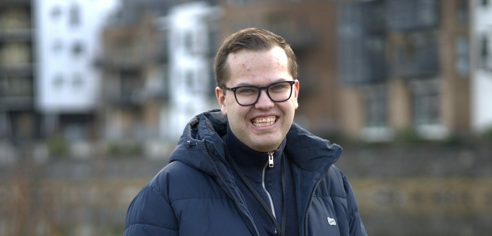 Trym Eiksen Høgelid står framfor elva i Førde og smiler